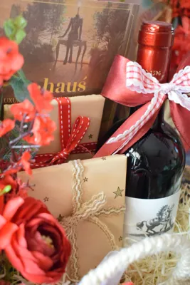 Close-up of the bottle, wrapped gifts and red floral finish