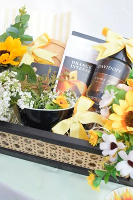 Coffee and chocolate arranged with a dark ceramic accent and sunflower-yellow details