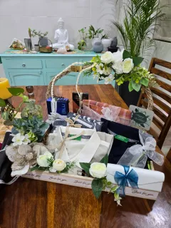 Birthday hamper with folded clothing, white flowers, wrapped gifts and an arched basket handle — photo supplied with Richa’s review